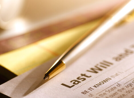 A Last Will And Testament sitting on a desk with a pen on top of it.