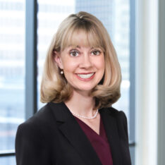 A professional headshot of Nicole Benjamin in front of windows.