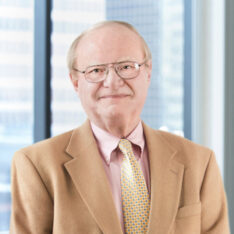 A professional headshot of E. Hans Lundsten in front of windows.