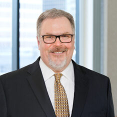 A professional headshot of Mike Morency in front of windows.