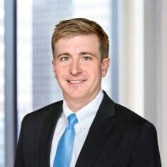 A professional headshot of Matthew Waters in front of windows.