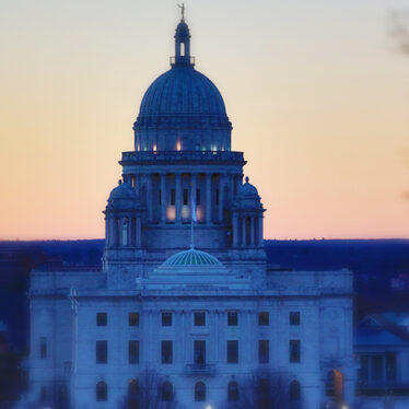 Rhode Island state house with the sun set in the background.