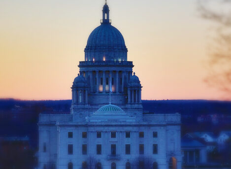 Rhode Island state house with the sun set in the background.