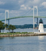 A picture of the Newport bridge in Newport, RI, with a lighthouse in the foreground.