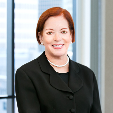Professional headshot of Victoria Almeida with windows in the background.