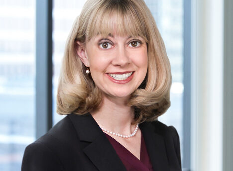 A professional headshot of Nicole Benjamin in front of windows.