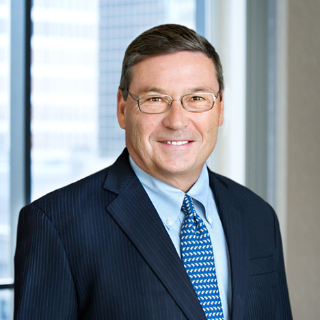 A professional headshot of Richard Beretta in front of windows.