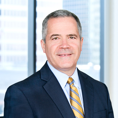 A professional headshot of Robert Brooks in front of windows.