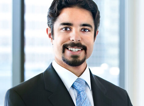 A professional headshot of Hamza Chaudary in front of windows.