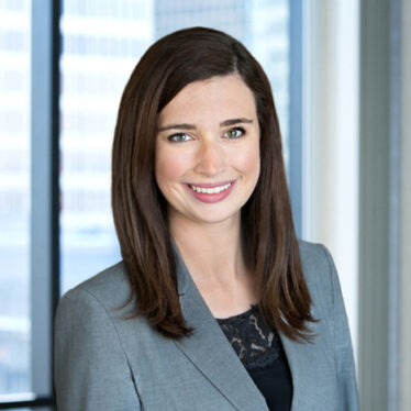 A professional headshot of Leslie Parker in front of windows.