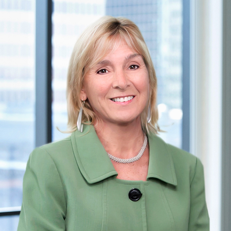 A professional headshot of Patricia Rocha in front of windows.