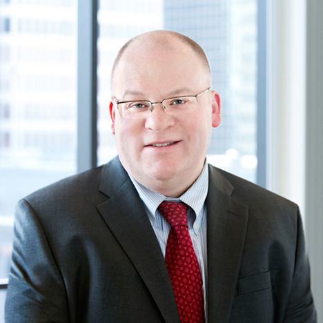 A professional headshot of Jonathan Sachs in front of windows.