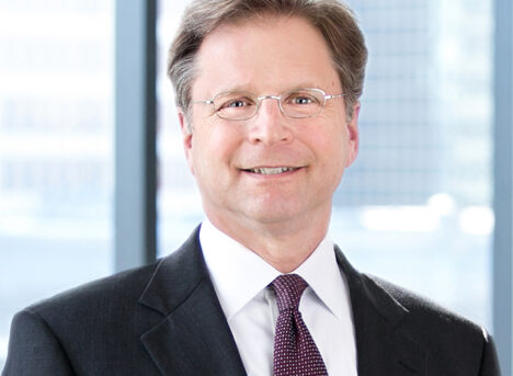 A professional headshot of Robert Stolzman in front of windows.