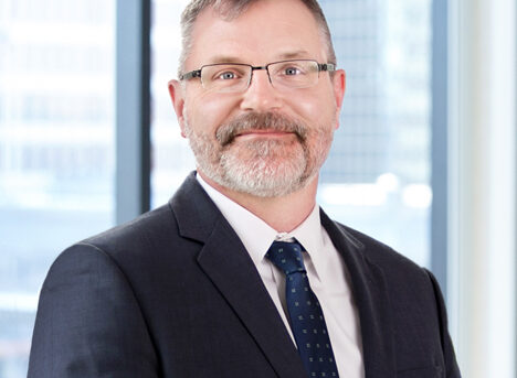 A professional headshot of Jeffrey Techentin in front of windows.