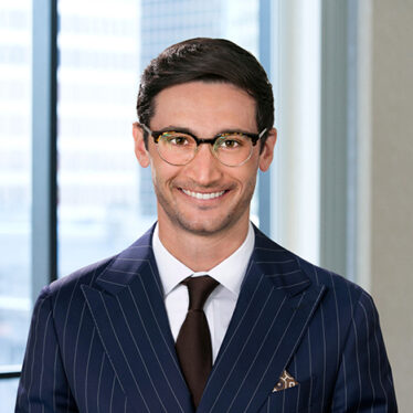 A professional headshot of Robert Craven in front of a row of windows.