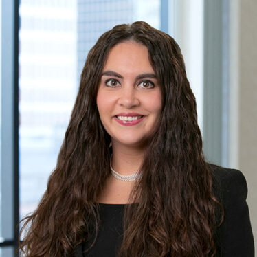 A professional headshot of Erin Hockensmith in front of windows.