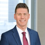 A professional headshot of David Webster in front of windows.